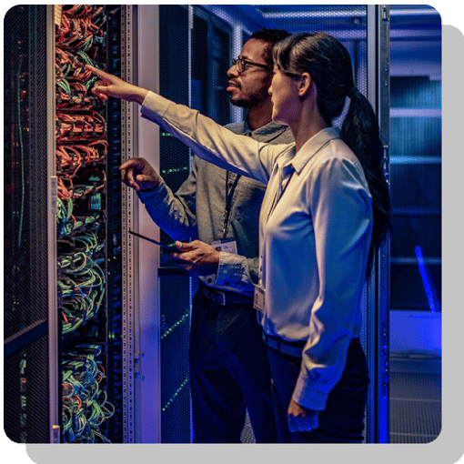 Two IT professionals inspecting a networking panel with like a thousand wires