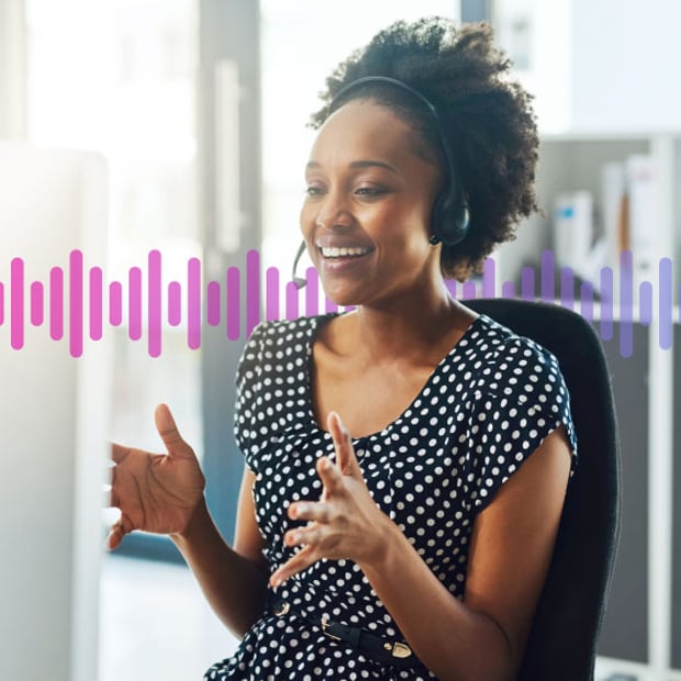 Photo of smiling agent wearing a headset and gesturing with her hands as she talks to a customer.