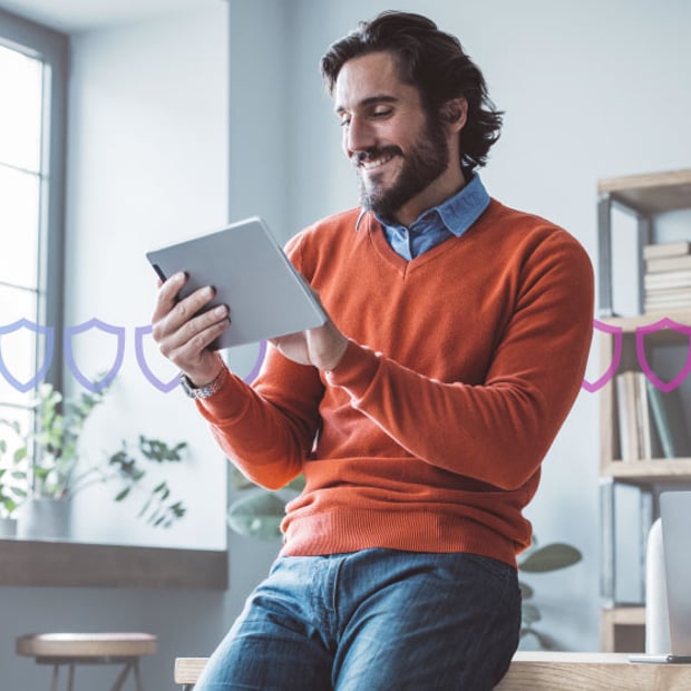 Photoillustration of a white man holding a tablet and leaning against a desk in an office; a ring of security badges runs through the center of the photo indicating security 