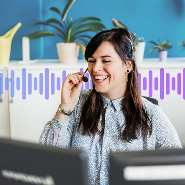 Photo of a smiling call center agent talking to customer on her headset as she prepares to make a warm transfer