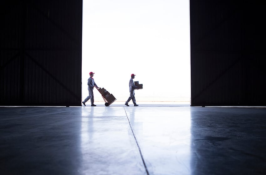 two people at a distance moving boxes