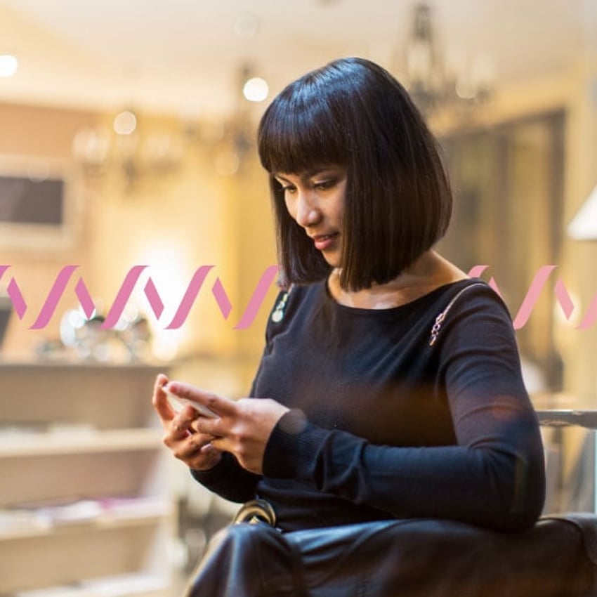 Photo of woman using her cell phone to work outside of an office setting